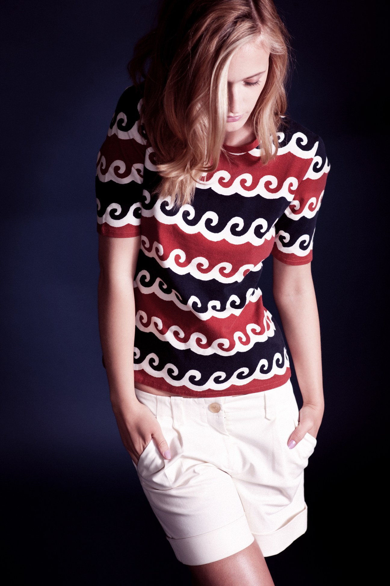 Woman wearing red, black and white patterned T-shirt by Frei Und Apple with white shorts.