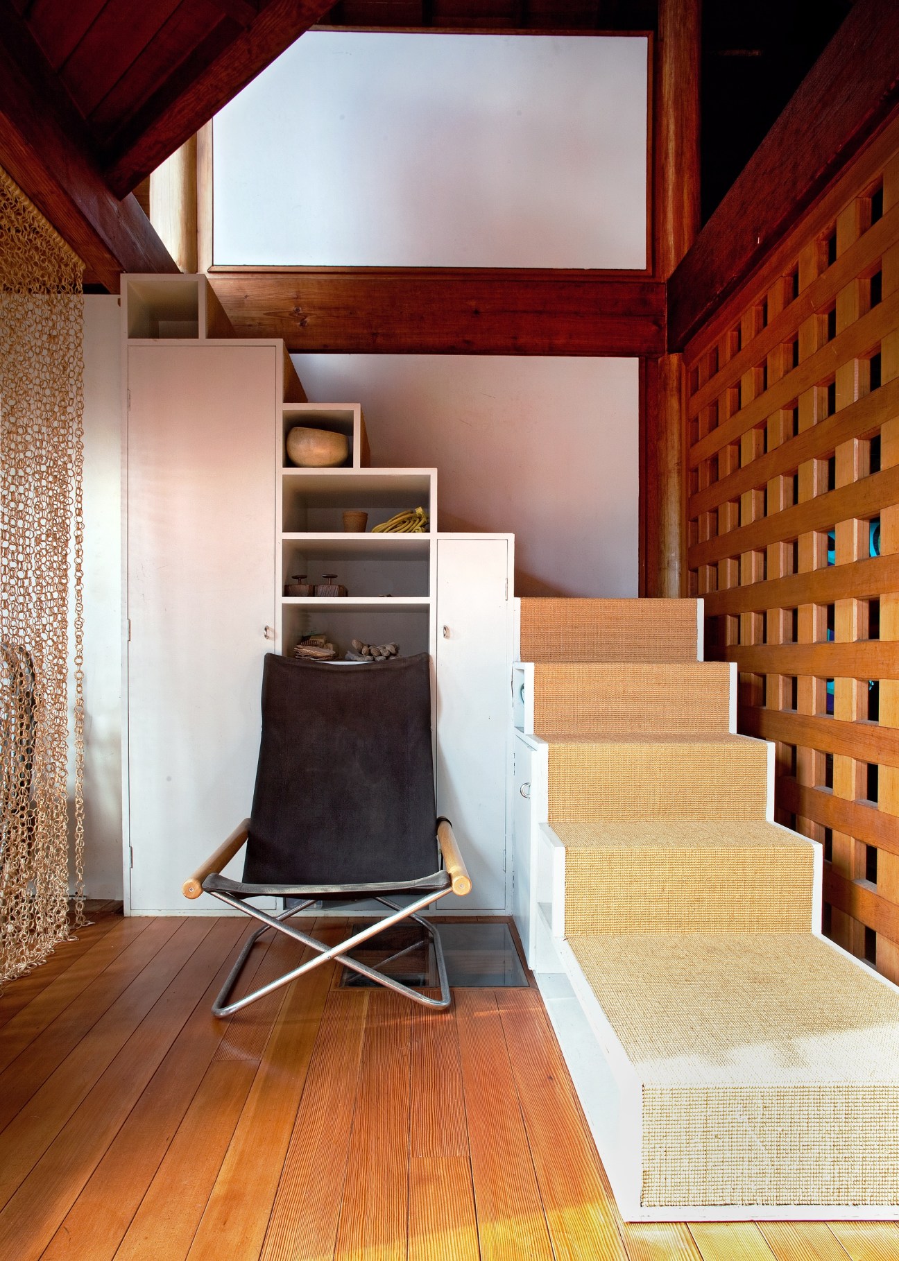 Tatami-covered staircase with a folding NY Chair by Takeshi Nii and wooden lattice wall detail.
