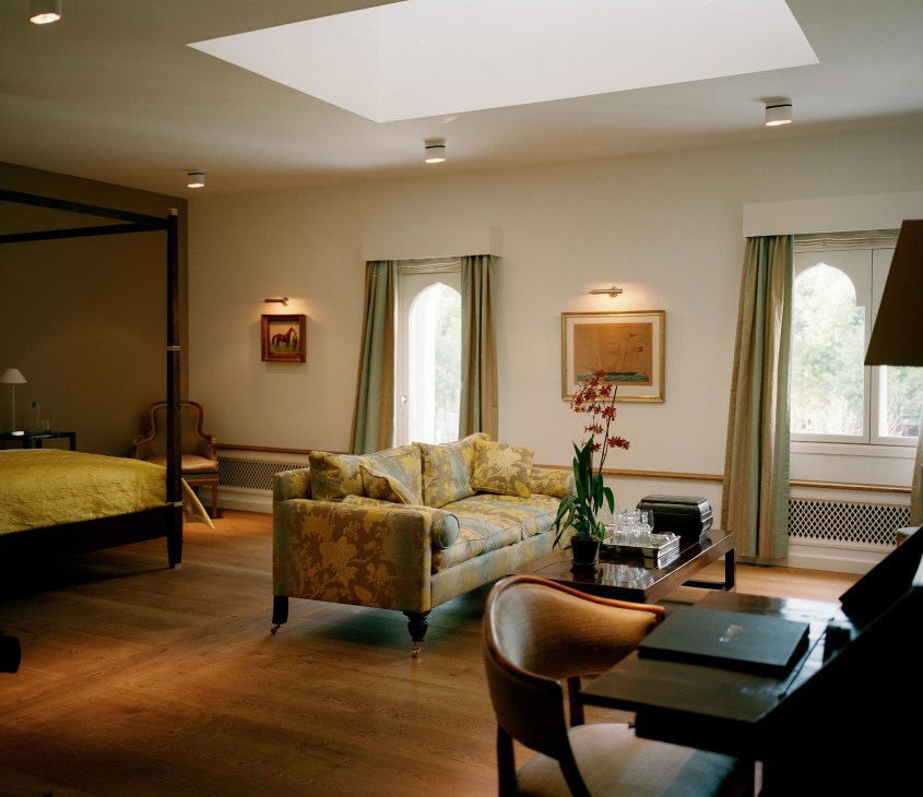 Hotel Nimb guest room with four-poster bed, patterned sofa, skylights, and minimalist Scandinavian furnishings.