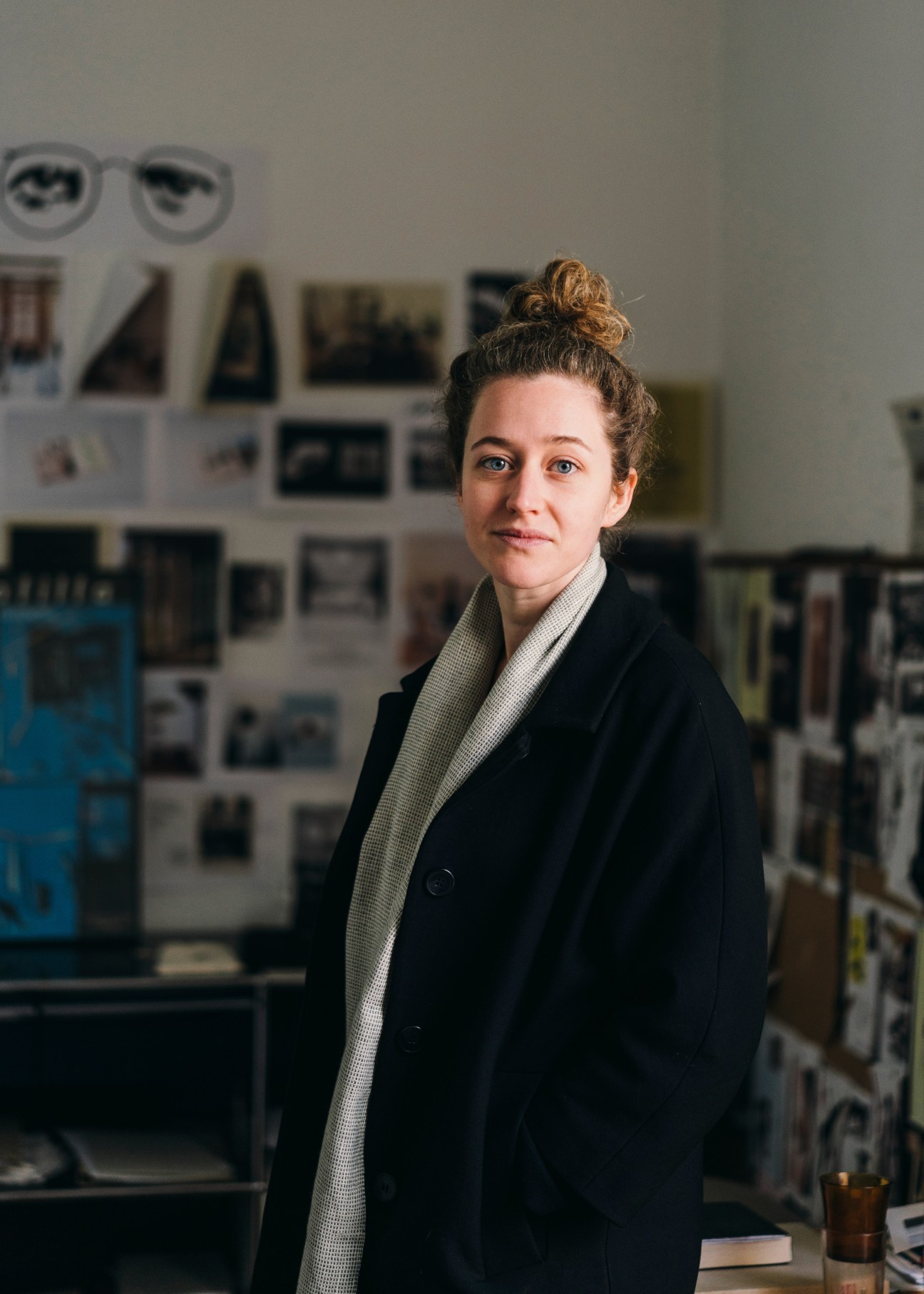 Nina Ordeig Cole stands in Santa & Cole's headquarters, a converted primary school, with design materials visible on the wall behind her.
