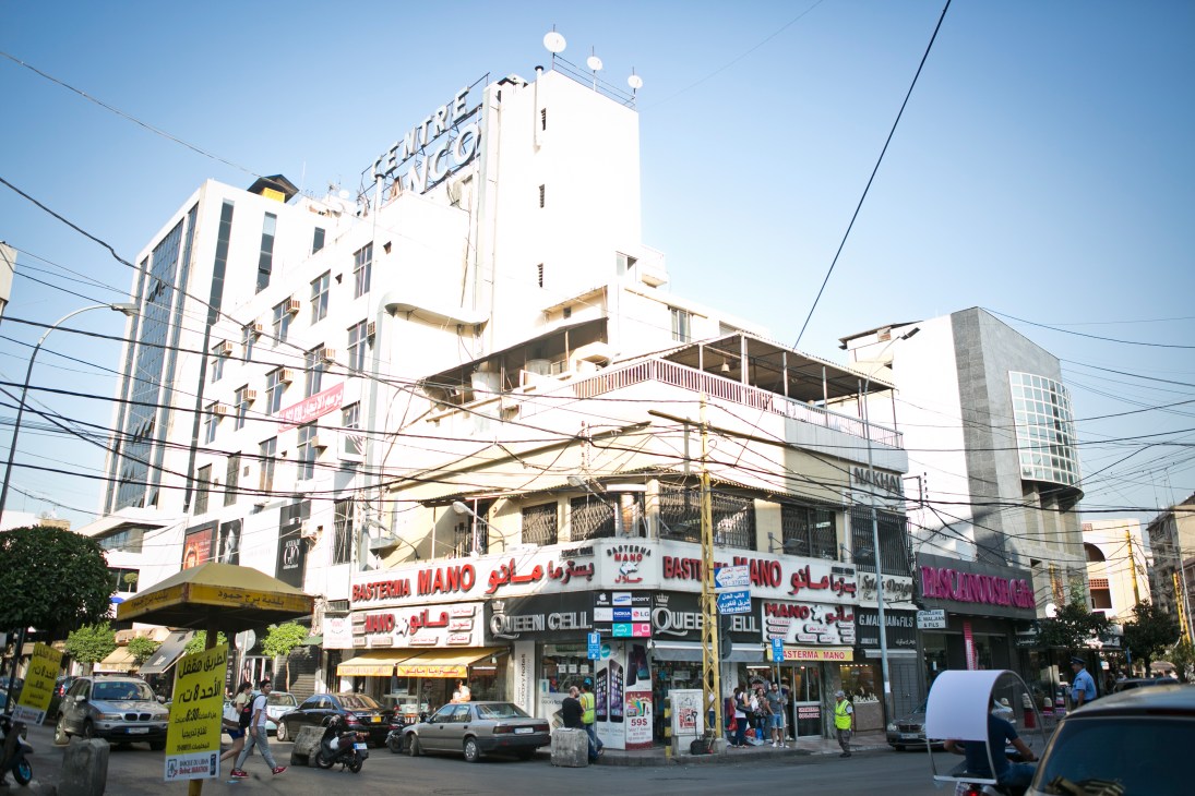 Street view of Bourj Hammoud with mixed-use buildings, shops, and signage in Arabic and English.