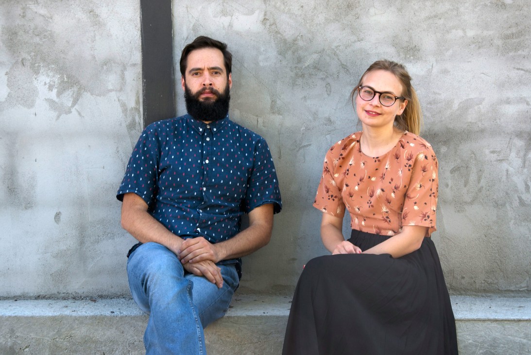 Two designers, Cosmin Cioroiu and Kathrine Lønstad, sit against a concrete wall in their Noidoi design studio.