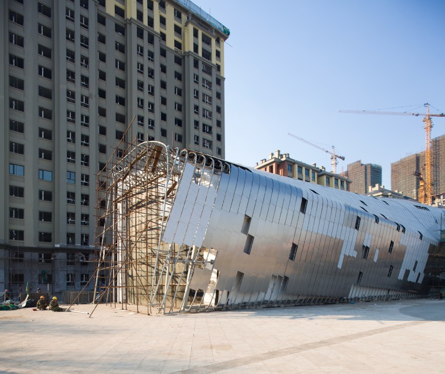 MAD Architects' whale-shaped Wood Sculpture Museum under construction in Harbin with metal plating and scaffolding.
