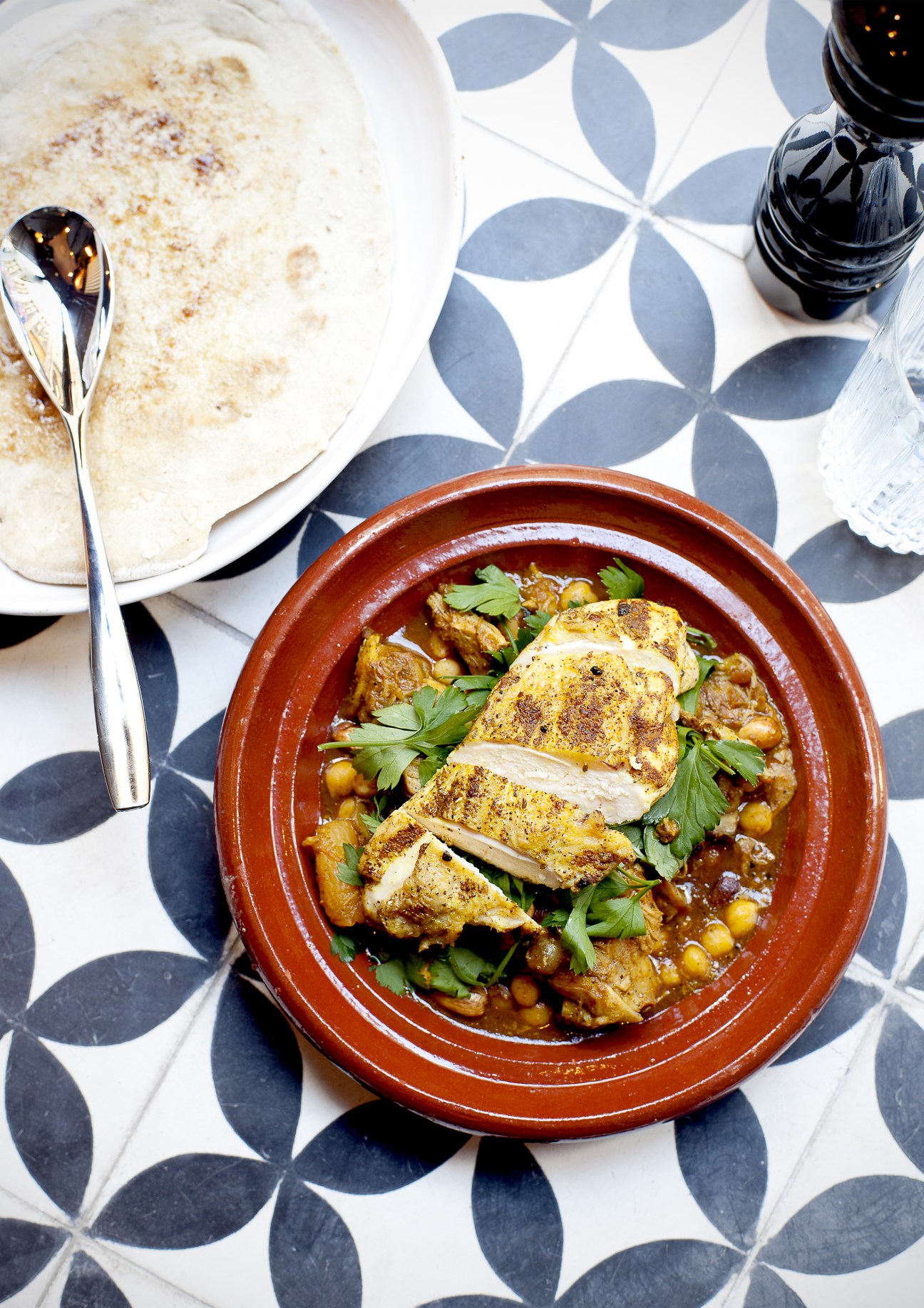 Spiced braised beef tagine with chickpeas and parsley in terracotta bowl at Nosh and Chow.