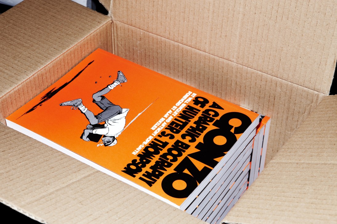 Stack of graphic novels with orange cover featuring illustrated figure and black text about Hunter S Thompson.