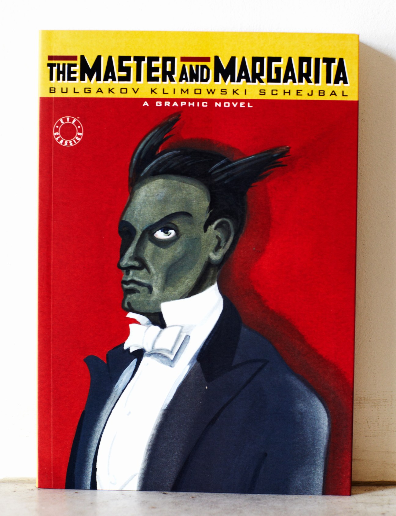 The Master and Margarita graphic novel cover with yellow title on red background and stylized portrait.