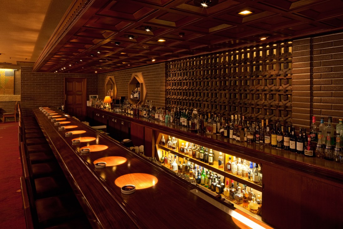 Long polished cherry-wood bar counter with illuminated seats at the Old Imperial Bar in Tokyo