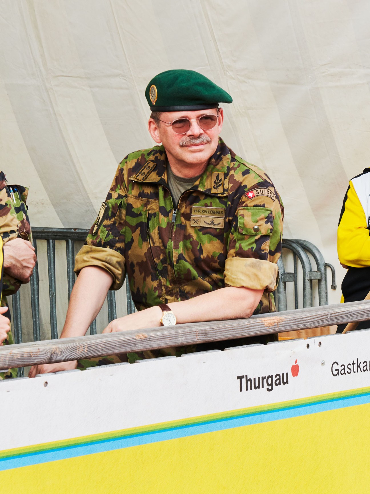Swiss military officer in camouflage uniform and green beret at Olma fair event.