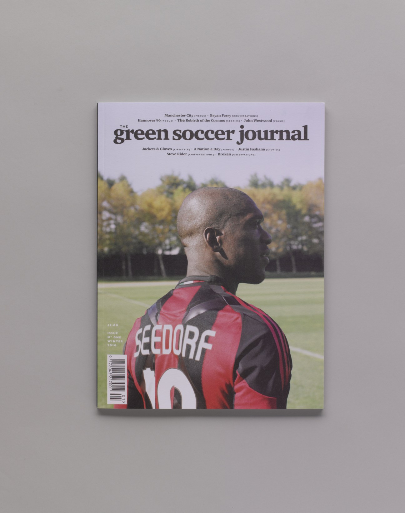 The Green Soccer Journal magazine cover featuring a footballer in a red and black striped jersey.