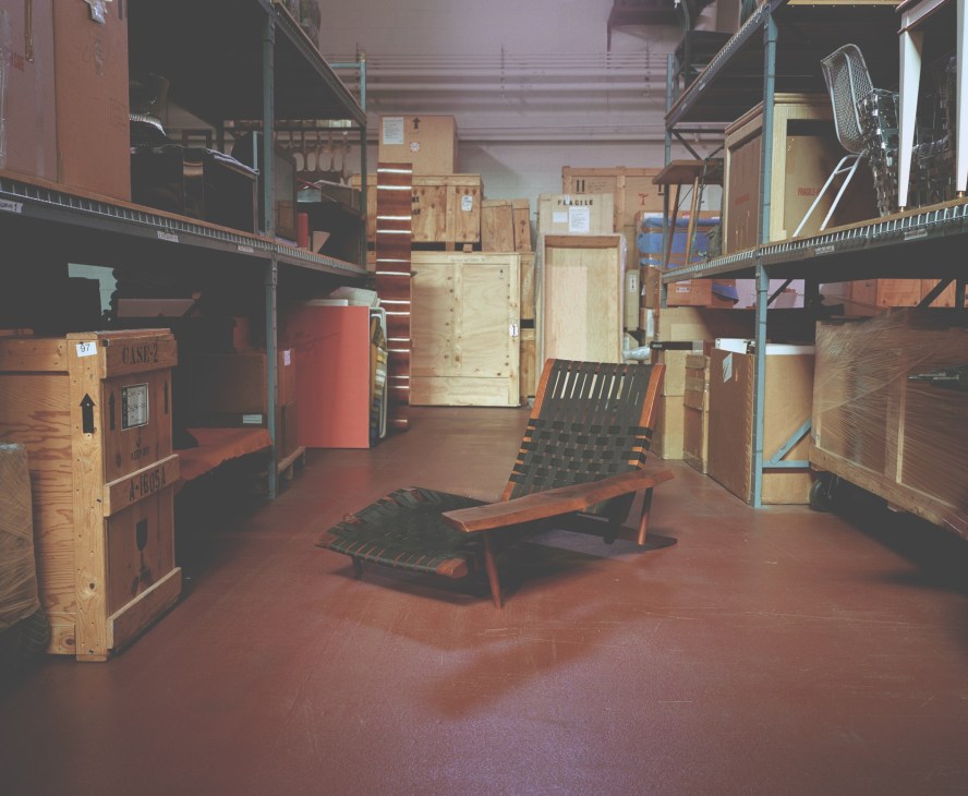 Wright's warehouse storage facility with wooden crates, vintage furniture including a Nakashima lounge chair, and industrial shelving.