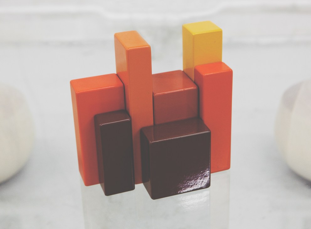 Colorful geometric object by Thomas Bernstrand with red, orange, yellow and dark brown rectangular forms.