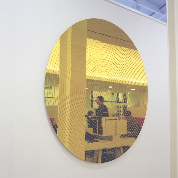 Oval acrylic mirror with concentric gold-lined pattern by Ohn Armleder Oltar.