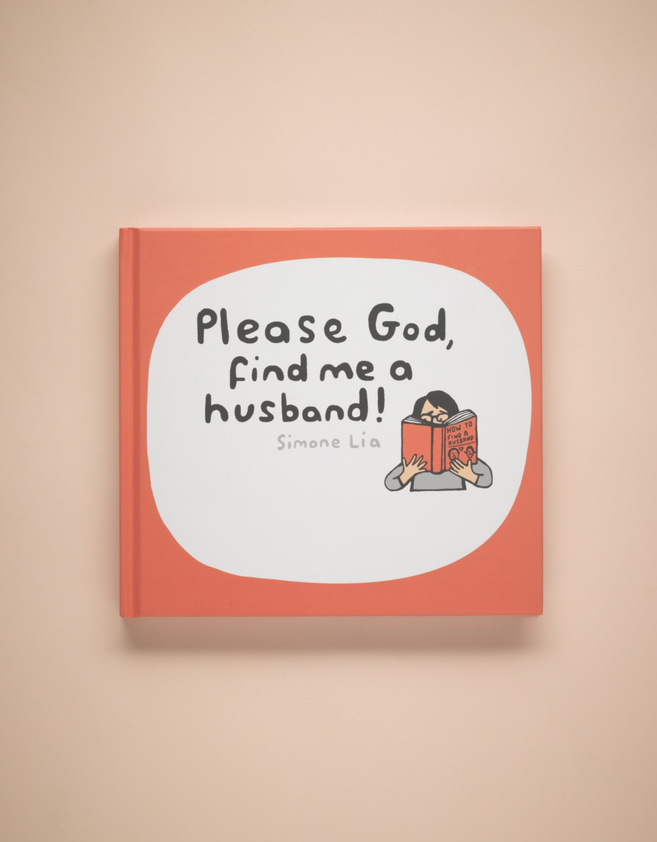 Simone Lia's graphic novel "Please God, Find me a Husband!" with coral cover and illustrated character holding book.