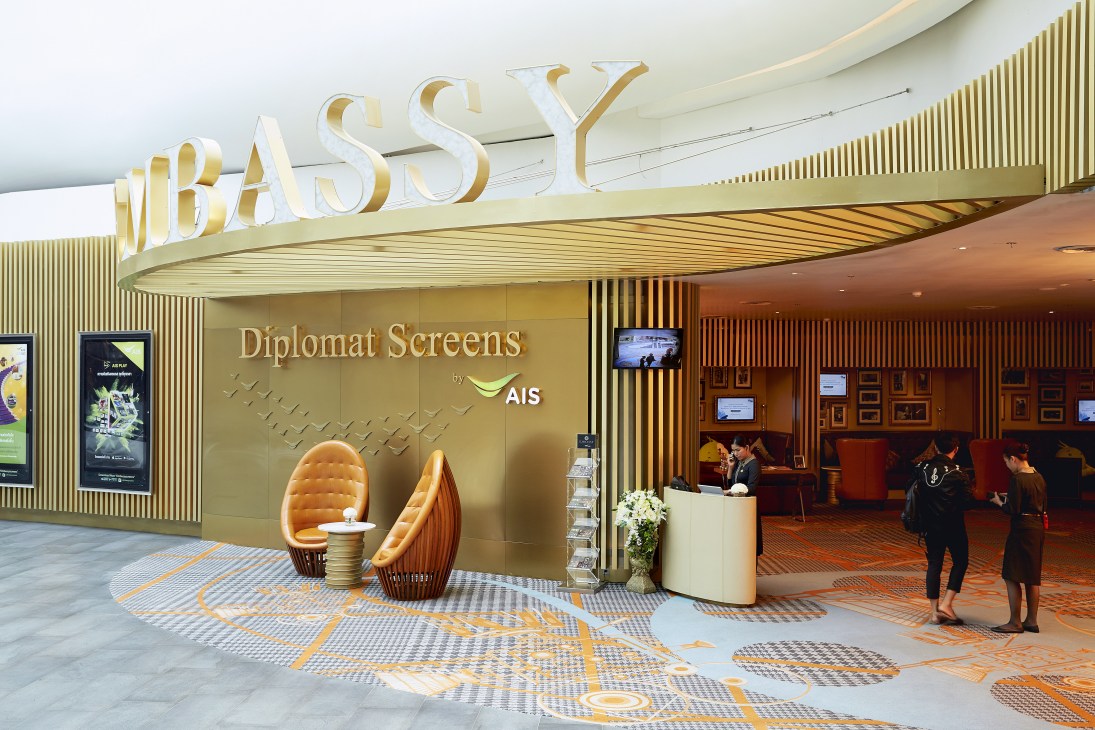 Diplomat Screens cinema entrance with gold signage next to Open House retail space in Central Embassy mall.