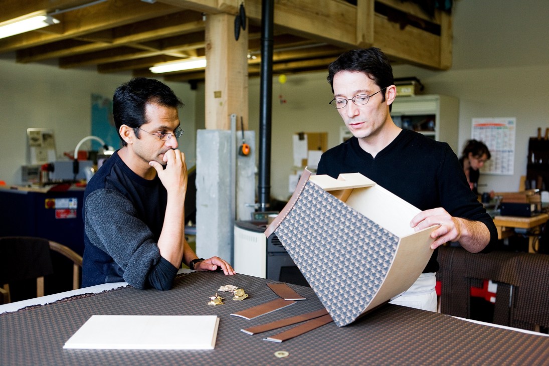 Ramesh Nair and Franck Tioni examine a patterned fabric sample in a workshop.