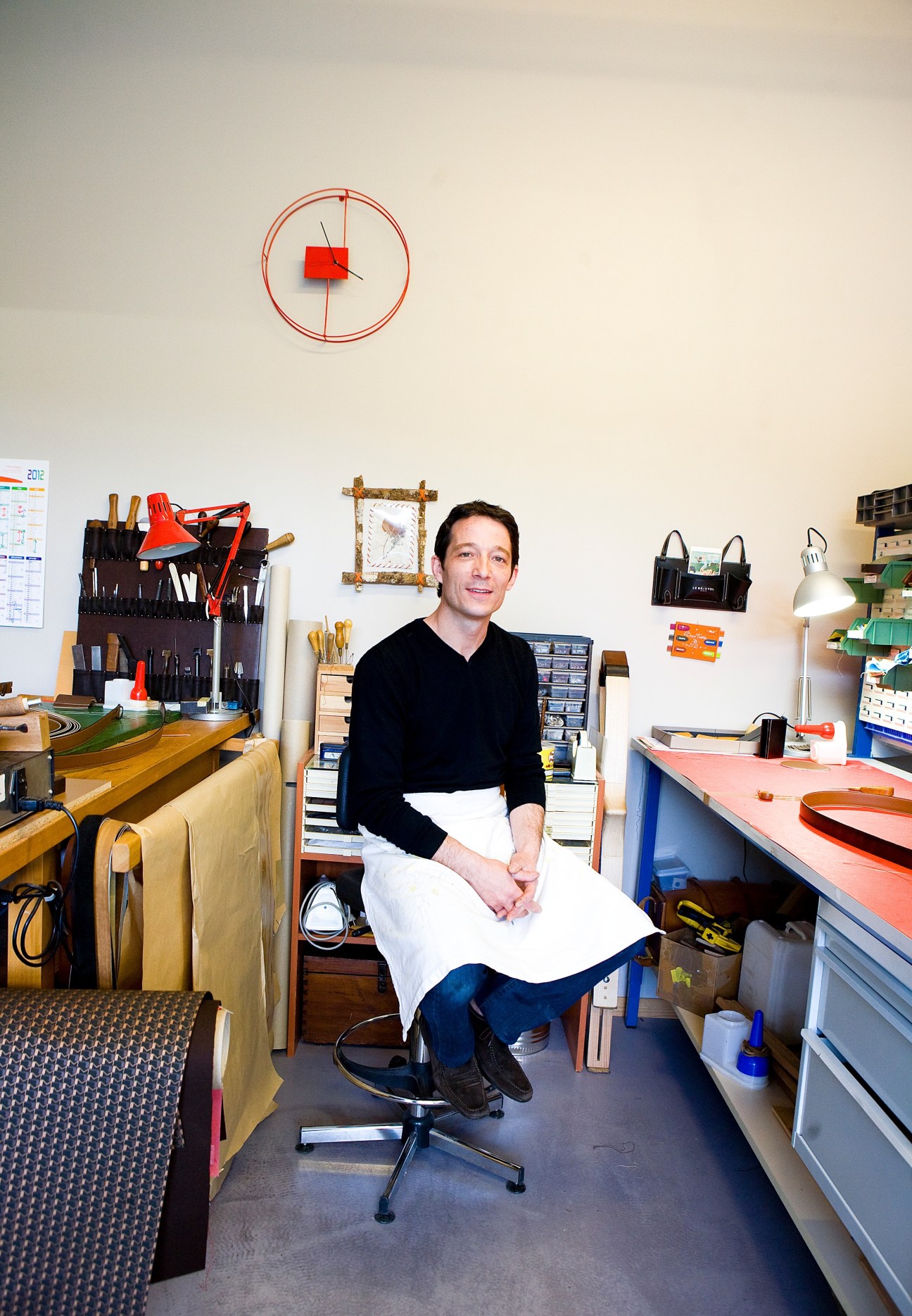 Franck Tioni sits in his workshop surrounded by tools and craft materials used for trunk making.