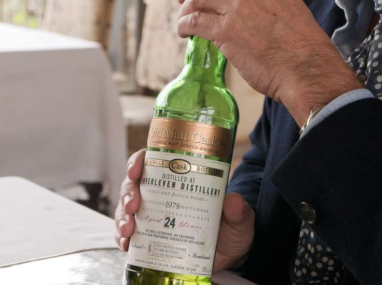 Man holding a bottle of 24-year-old single malt Scotch whiskey from Tinterlen Distillery