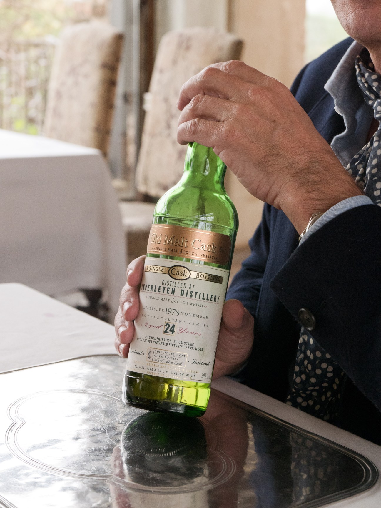 Man holding a bottle of 24-year-old single malt Scotch whiskey from Tinterlen Distillery