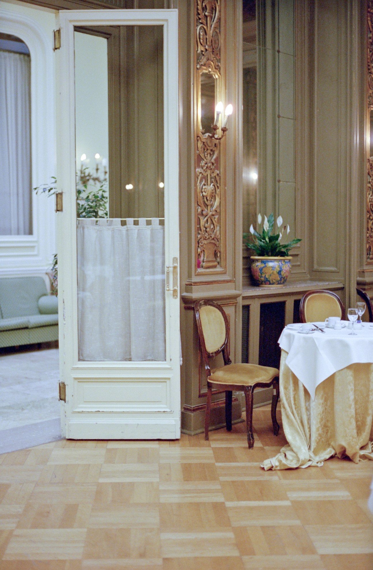 Elegant breakfast room at Grand Hotel Et Des Palmes with ornate mirrors, classical chairs, and potted flowers.