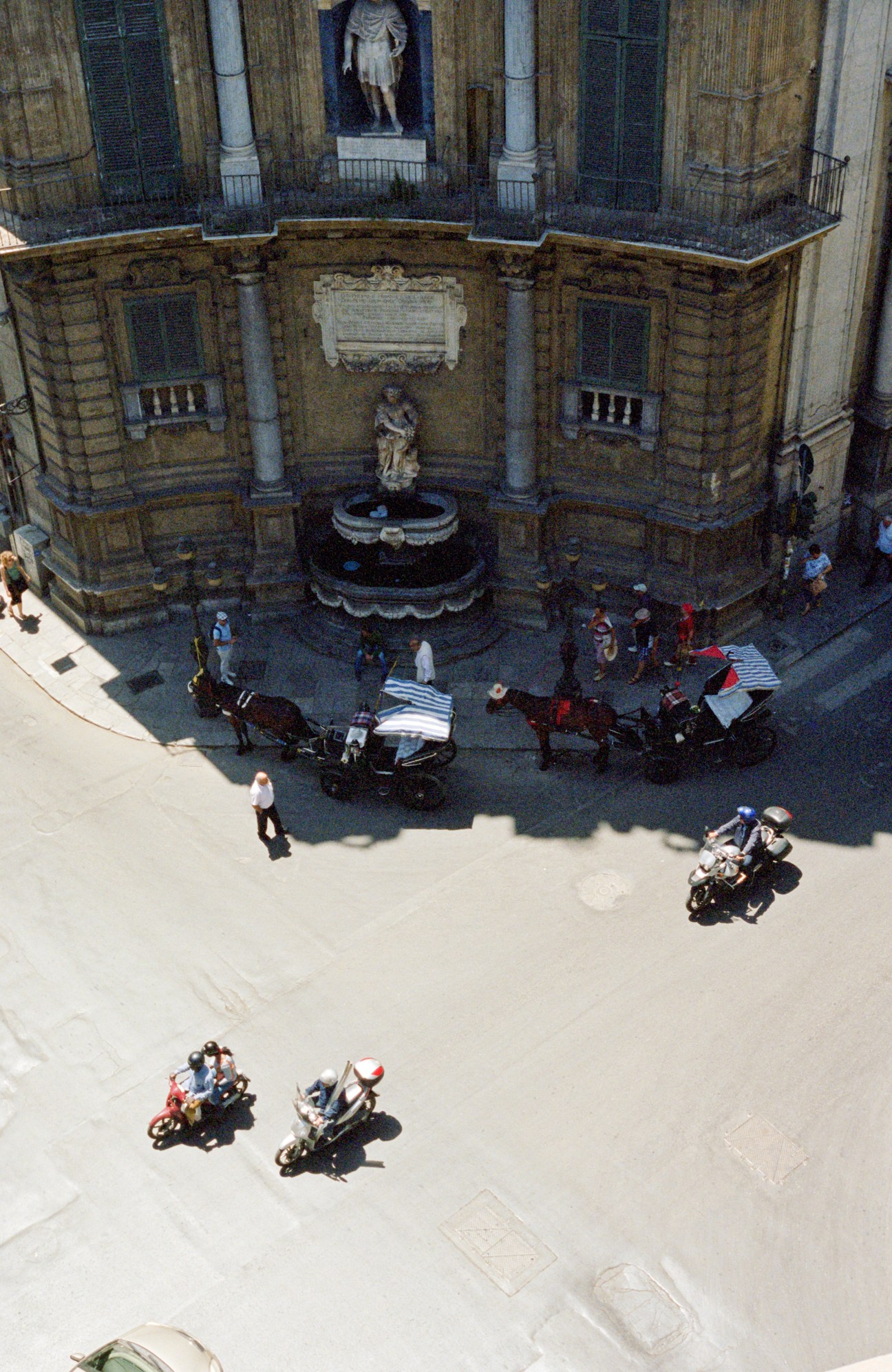 Aerial view of the baroque Quattro Canti intersection in Palermo with mounted police and pedestrians below.