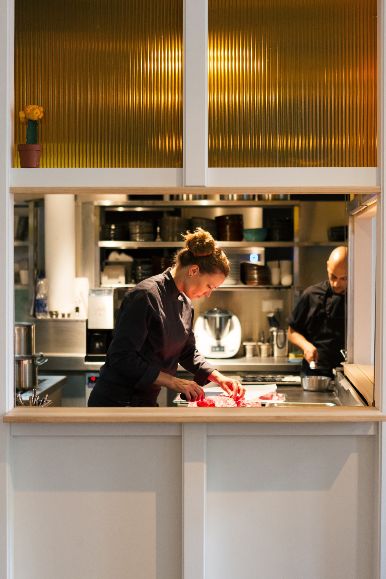 Chef Sophia Rudolf prepares food at an open kitchen counter at Panama restaurant in Berlin.
