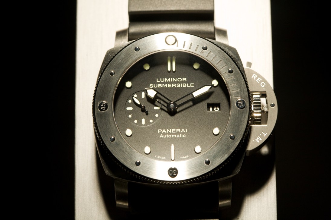 Panerai Luminor Submersible automatic watch with dark dial and metal bracelet on white background.