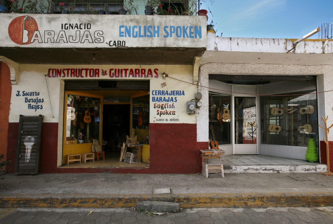 Guitar shops on Paracho's main street displaying instruments in windows and storefronts.