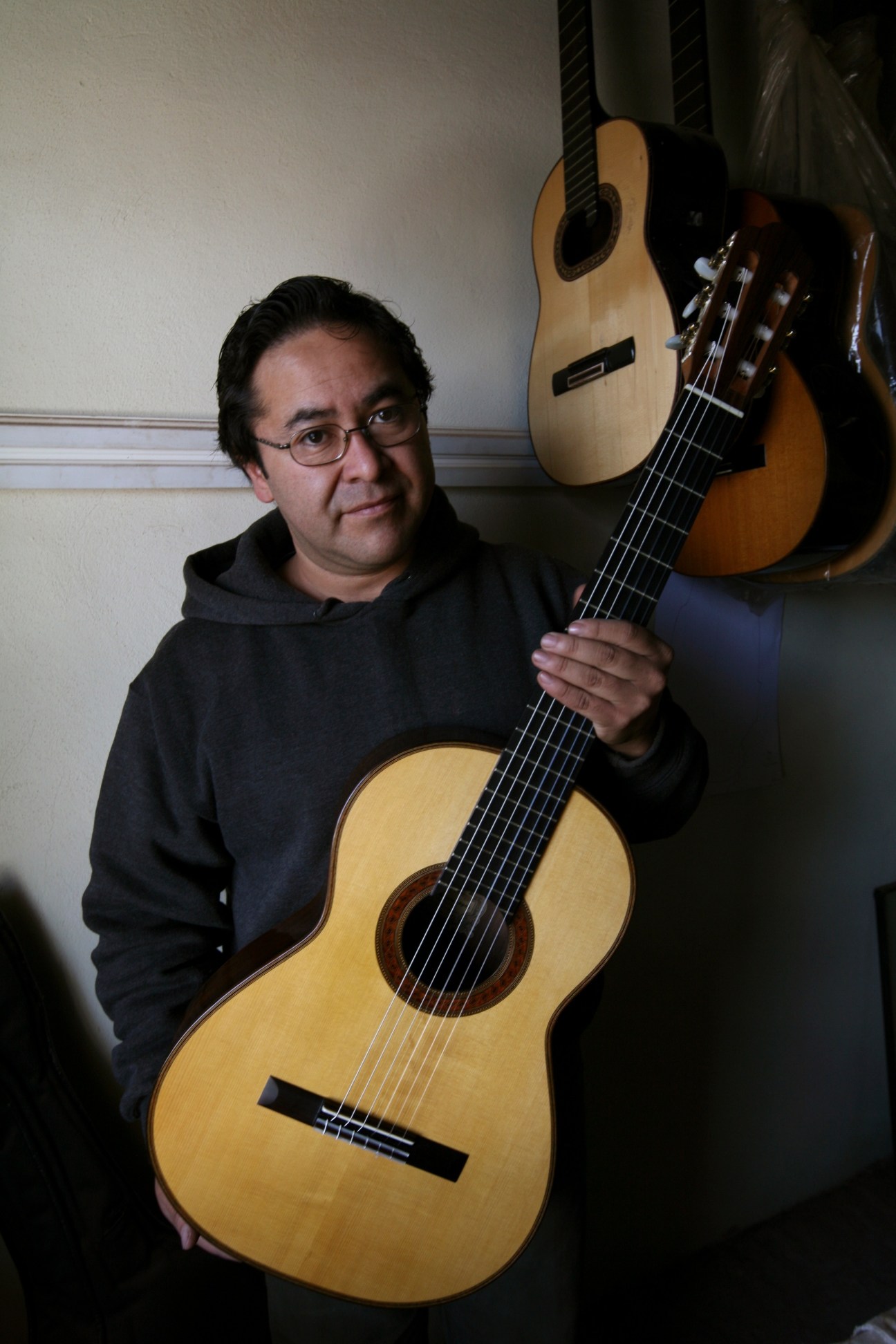 Abel García López, a Mexican luthier, holds one of his handcrafted classical guitars in his workshop.