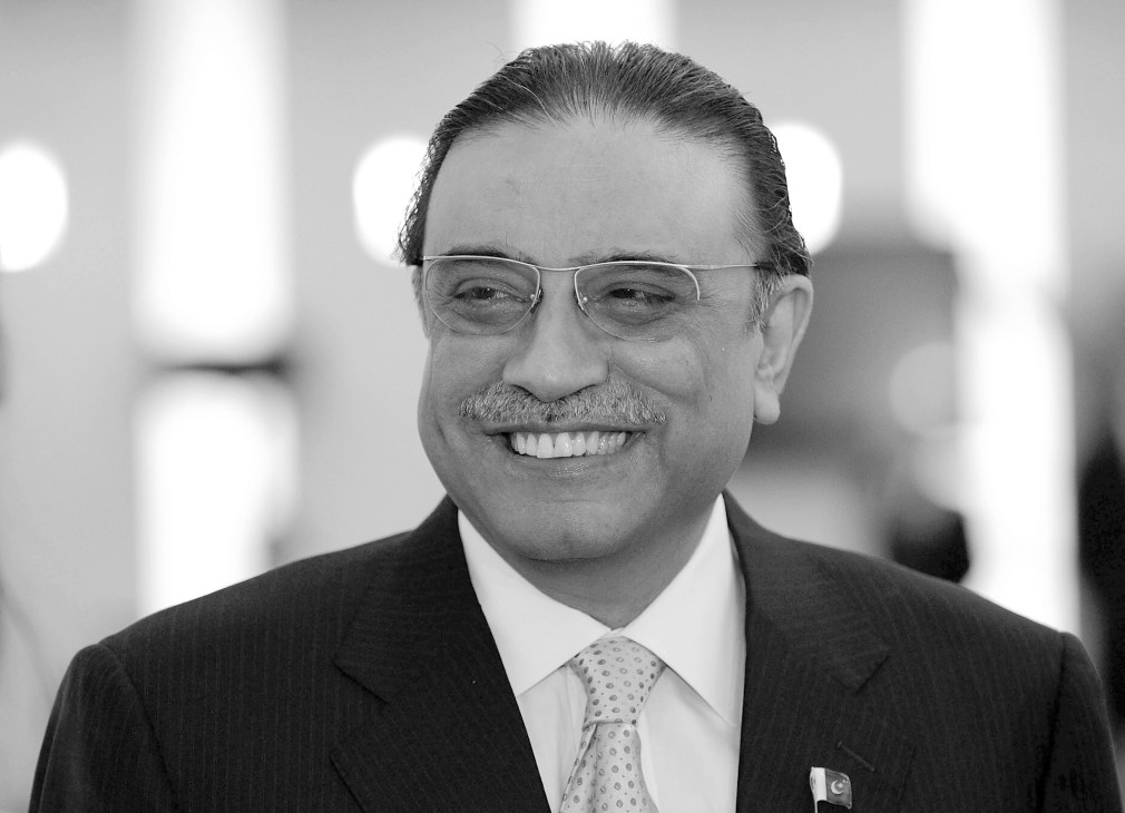 Pakistani president Asif Ali Zardari smiling at the camera wearing glasses and a suit with patterned tie.