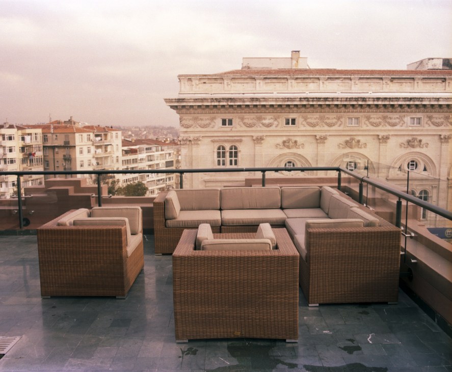 Park Hyatt Istanbul presidential suite terrace with rattan seating overlooking the historic Maçka Palas building and city.
