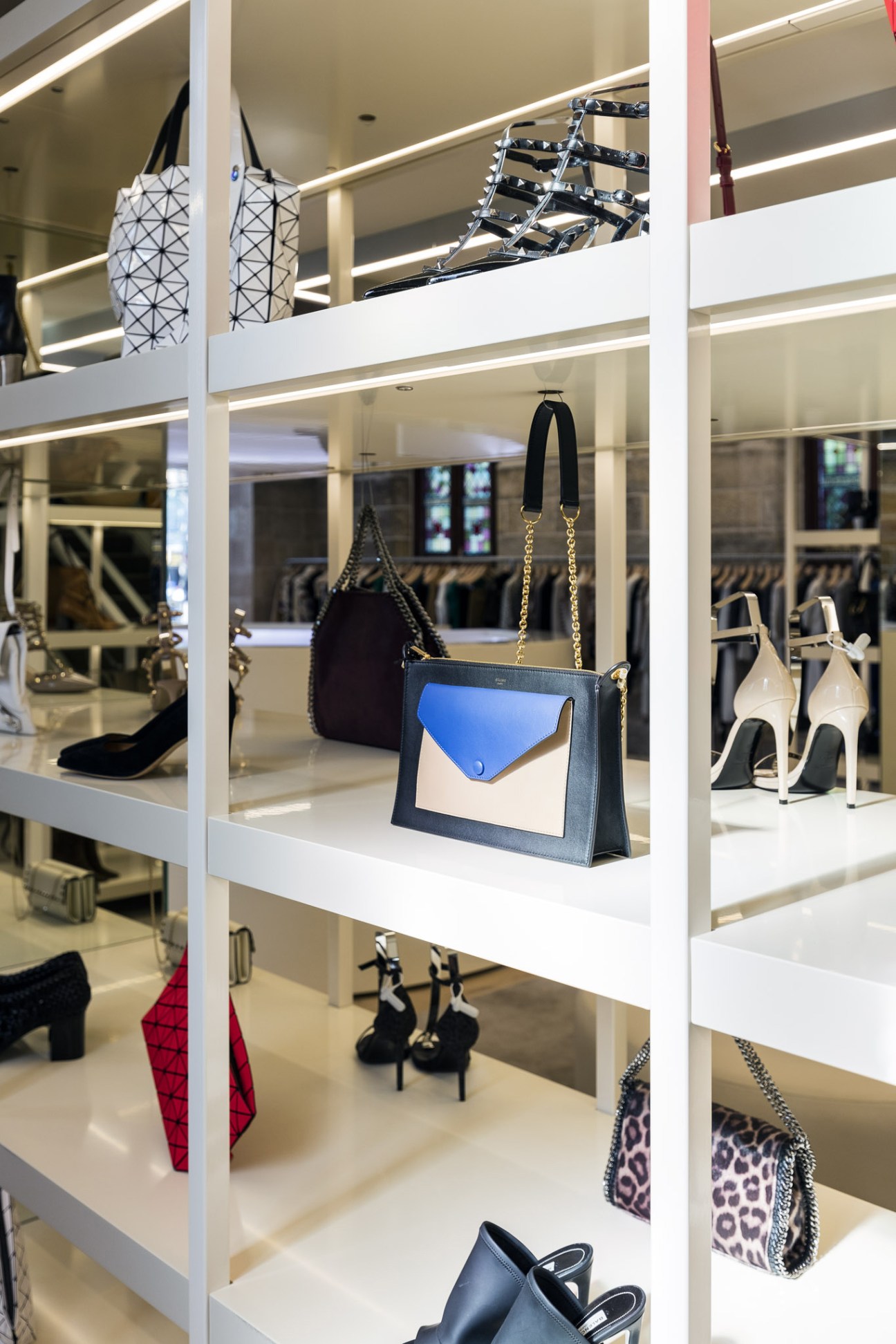 White shelving unit displaying handbags, shoes, and accessories at Parlour X boutique in Sydney.