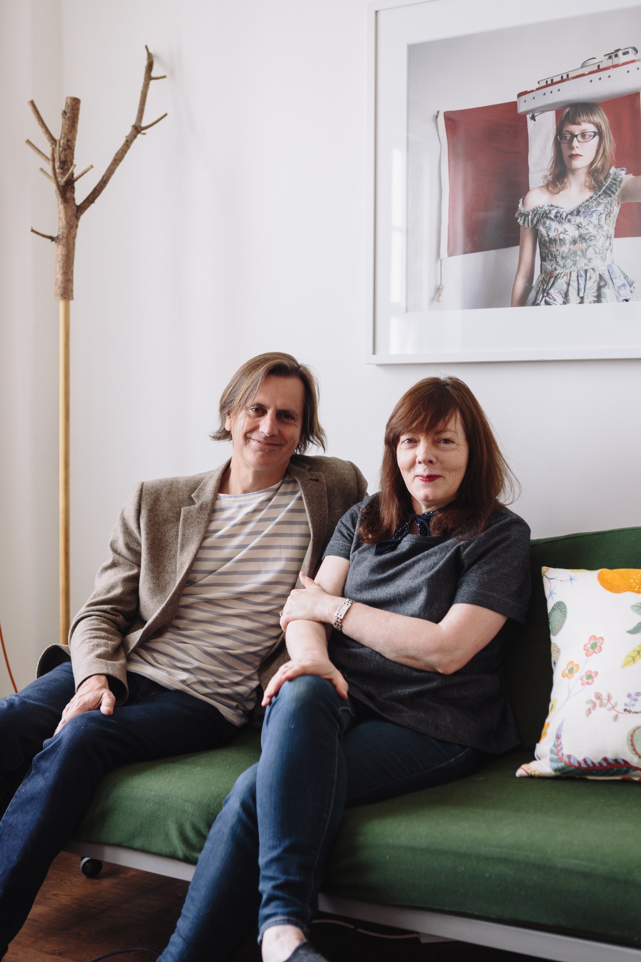 Architect Nicholas Stevens and his partner Deborah Smith sit on a green sofa in their Parnell apartment.