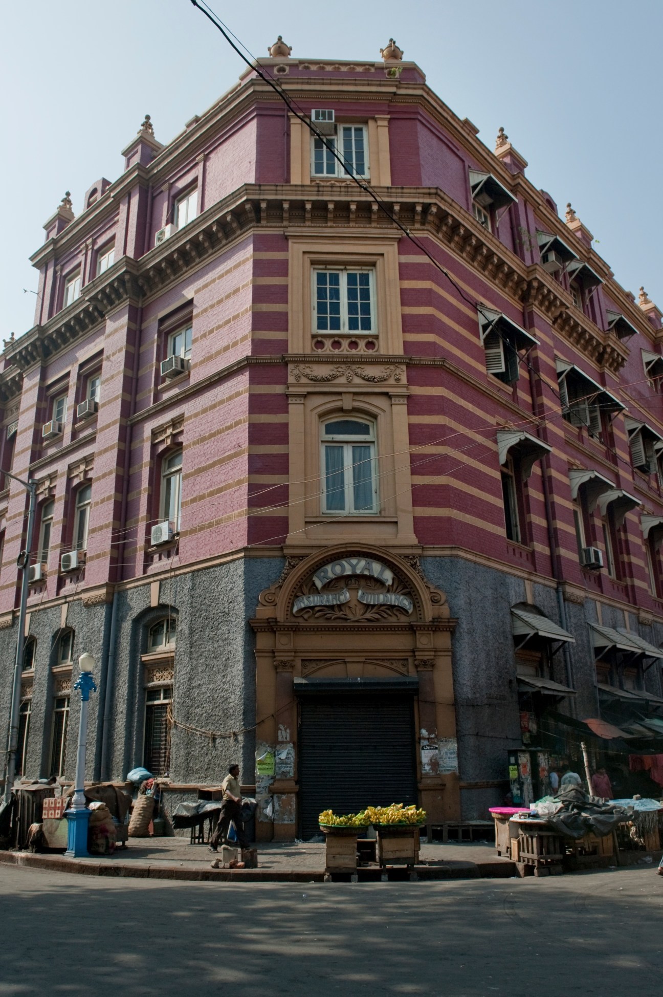 A recently renovated pink and tan striped colonial building with ornate architectural details near Raj Bhavan in Kolkata.