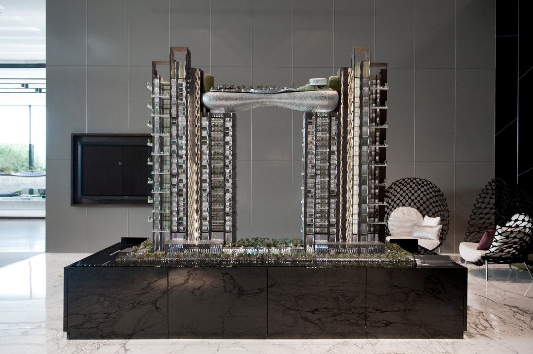 Architectural model of the Atmosphere building featuring twin towers connected by a cloud-shaped structure.