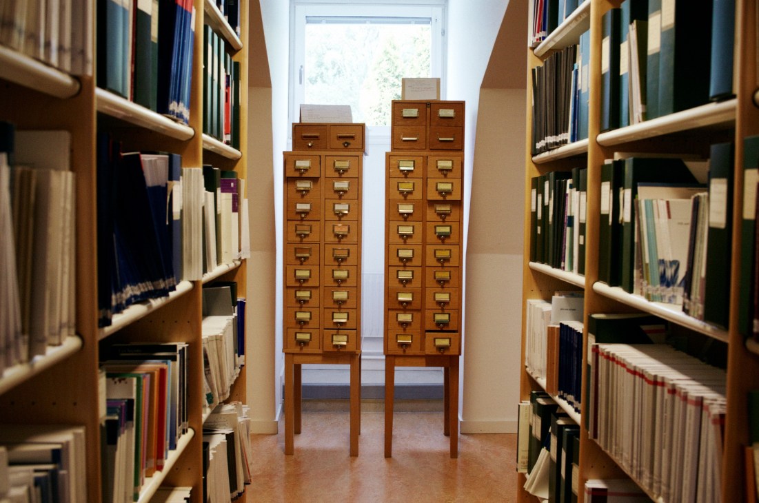 SIPRI library with wooden card catalog cabinets between bookshelves lining both walls.