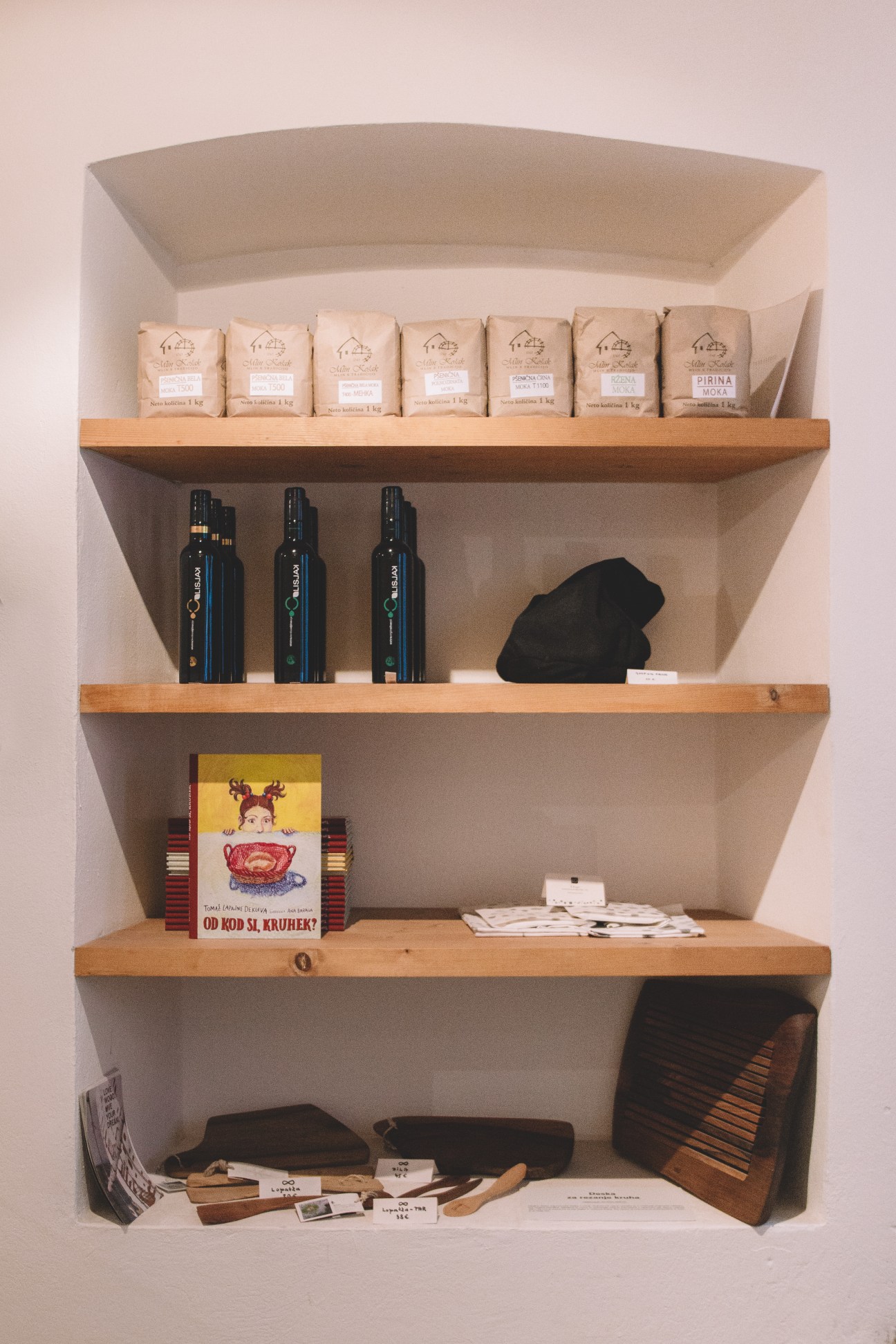 Interior shelving display at Pekarna Osem bakery showing packaged bread products and traditional baking tools.