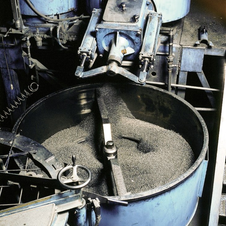 Pencil lead granules in a large industrial mixing bowl at Mitsubishi Pencil's factory.