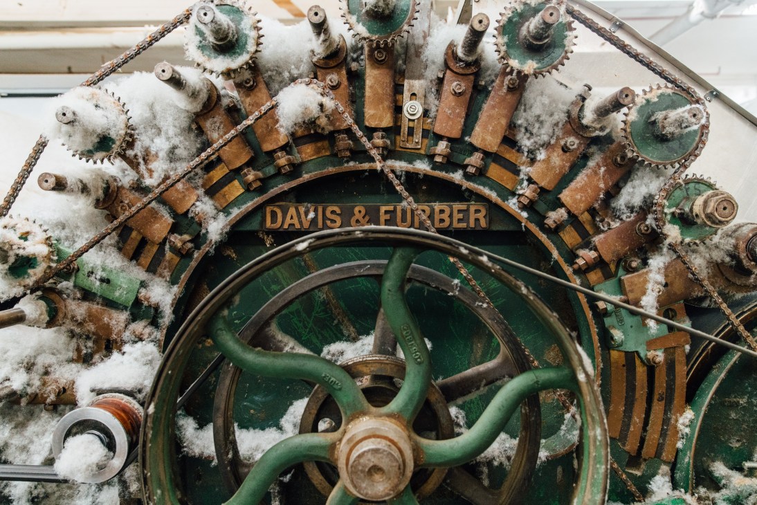 Davis & Furber industrial carding machine with snow-covered gears and green metal wheel.