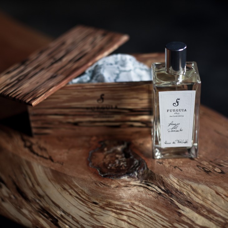 Fueguia 1833 perfume bottle with white label on wooden surface with reclaimed Patagonian wood box.