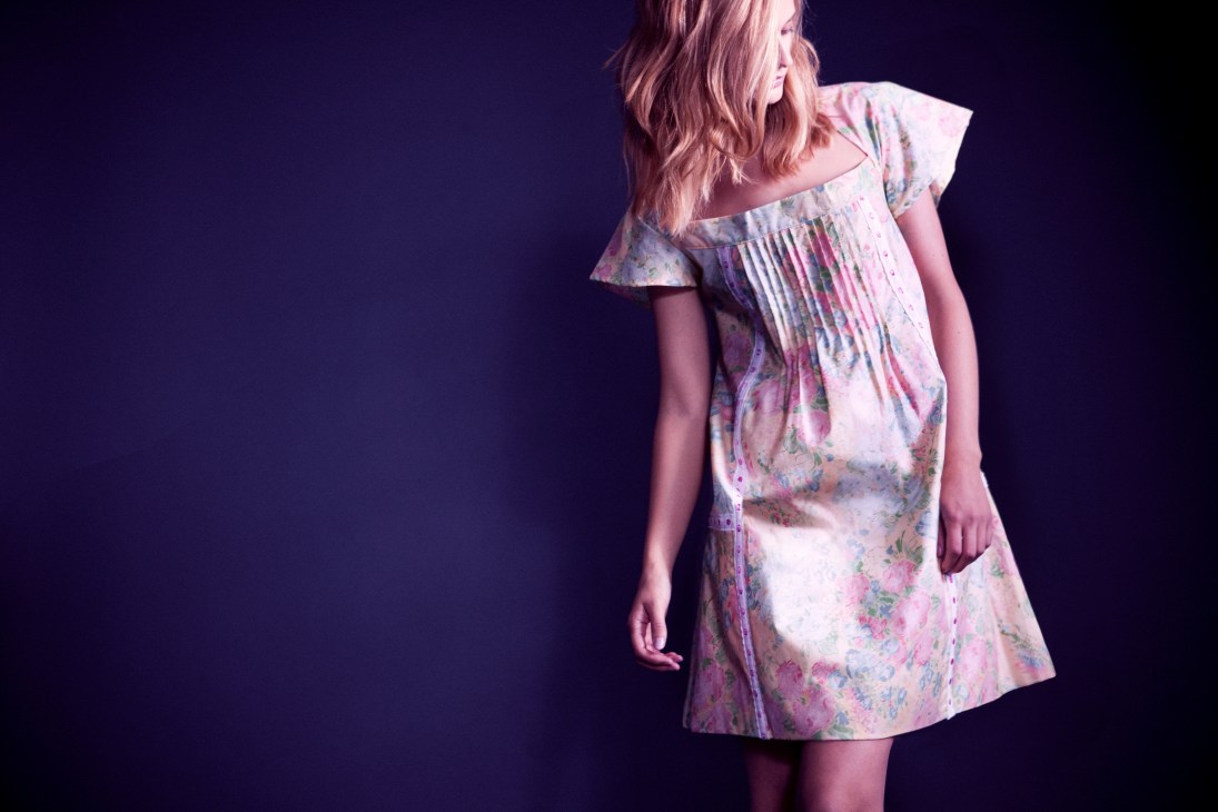 Woman wearing a floral-print cotton dress with ruffled off-shoulder sleeves by Amilod Zareg.