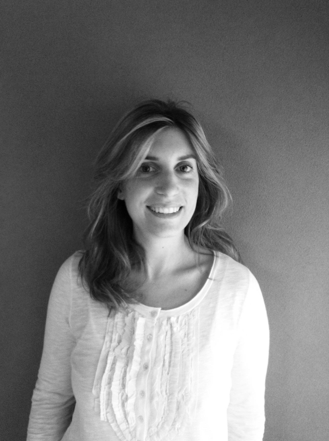 Black and white portrait of Carole Corm, co-owner of Editions de la Revue Phénicienne, smiling at camera.