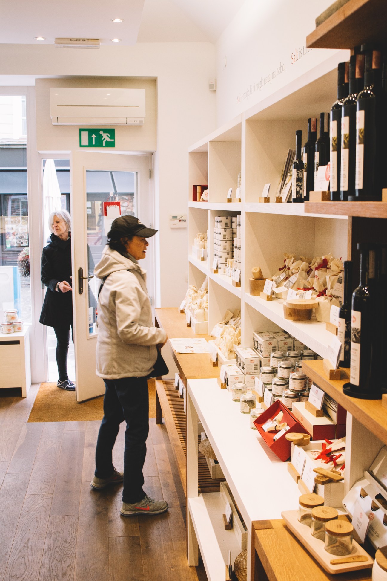Customer browsing shelves of packaged salt products at Piranske Soline shop in Ljubljana.