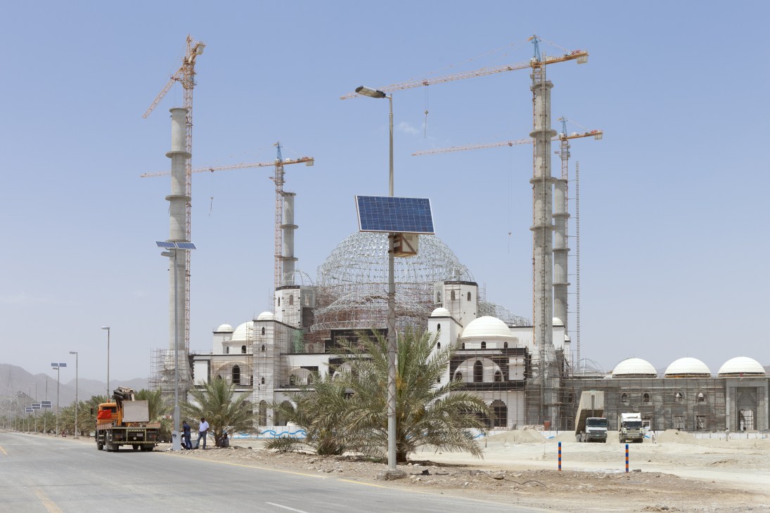 Sheikh Zayed Mosque under construction in Fujairah with solar panels and construction cranes.