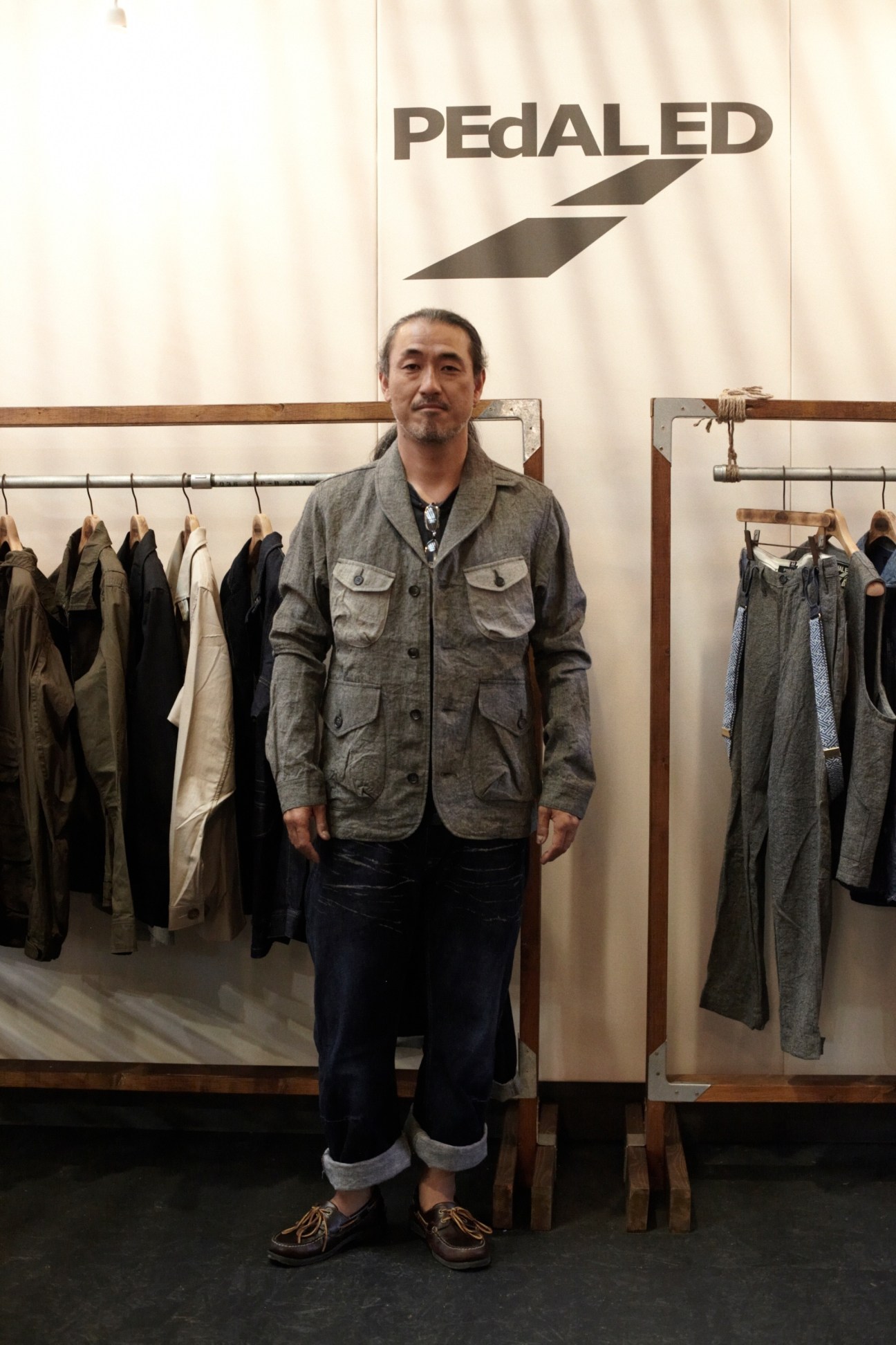 Hideto Suzuki wearing a grey linen Allen hacking jacket at the PEdALED showroom display.