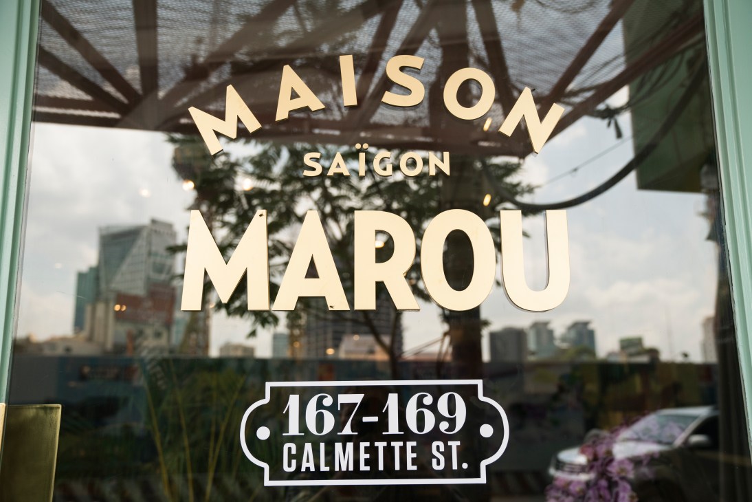 Maison Marou storefront window in Ho Chi Minh City with gold lettering and address on glass.