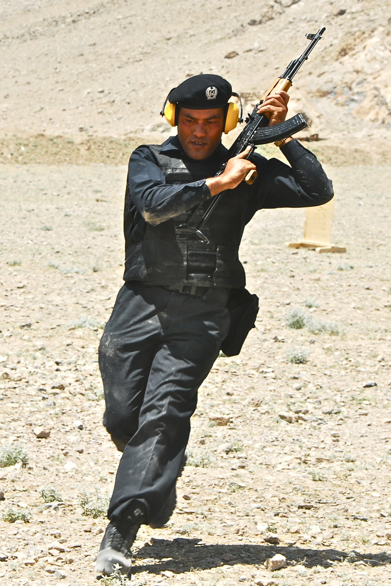 IDG Security member in tactical gear holding an assault rifle during training in a desert environment.