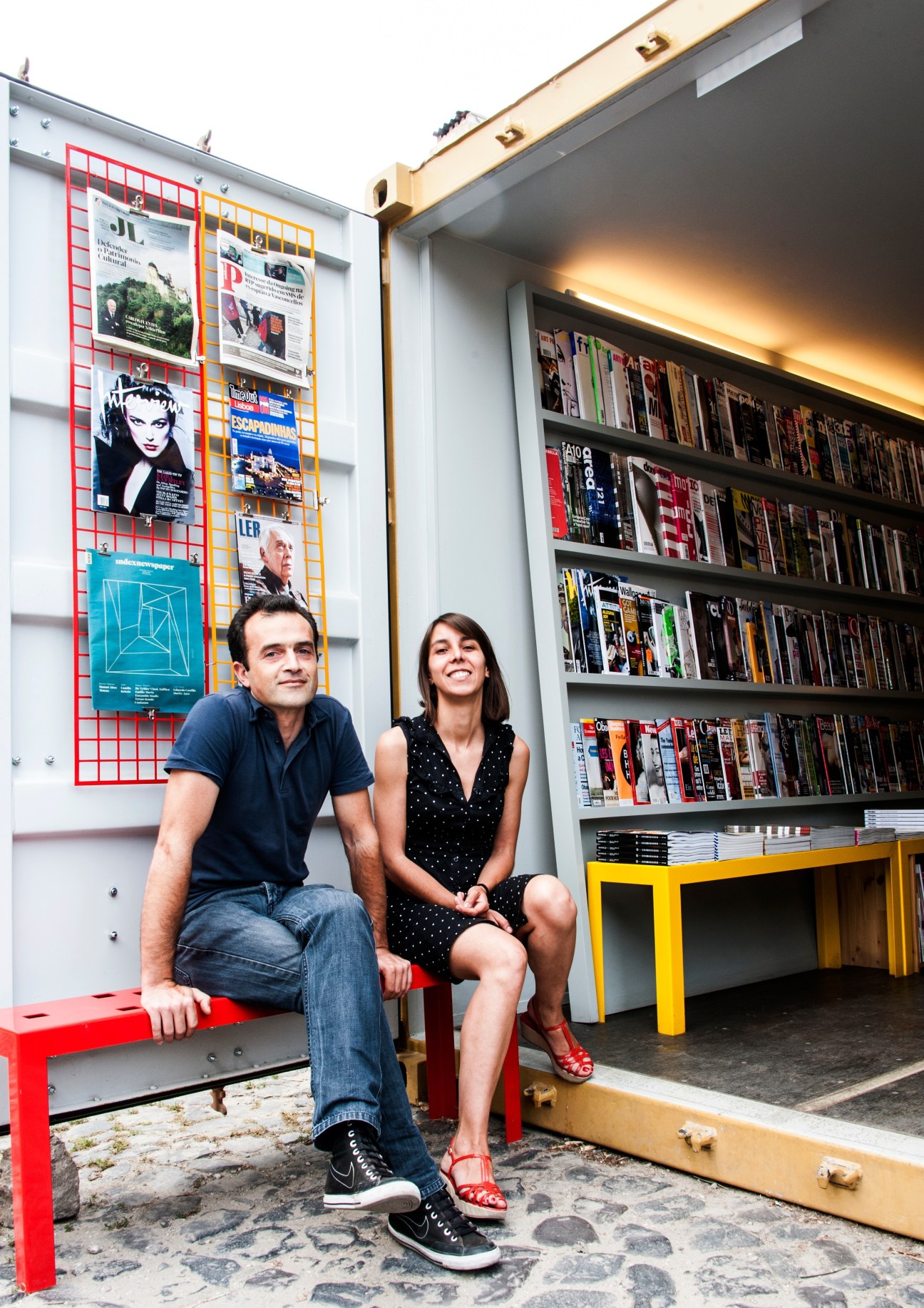 Carlota Ferrão and Pedro Sottomayor sit outside Mag Kiosk, their magazine shop in a recycled shipping container in Lisbon.