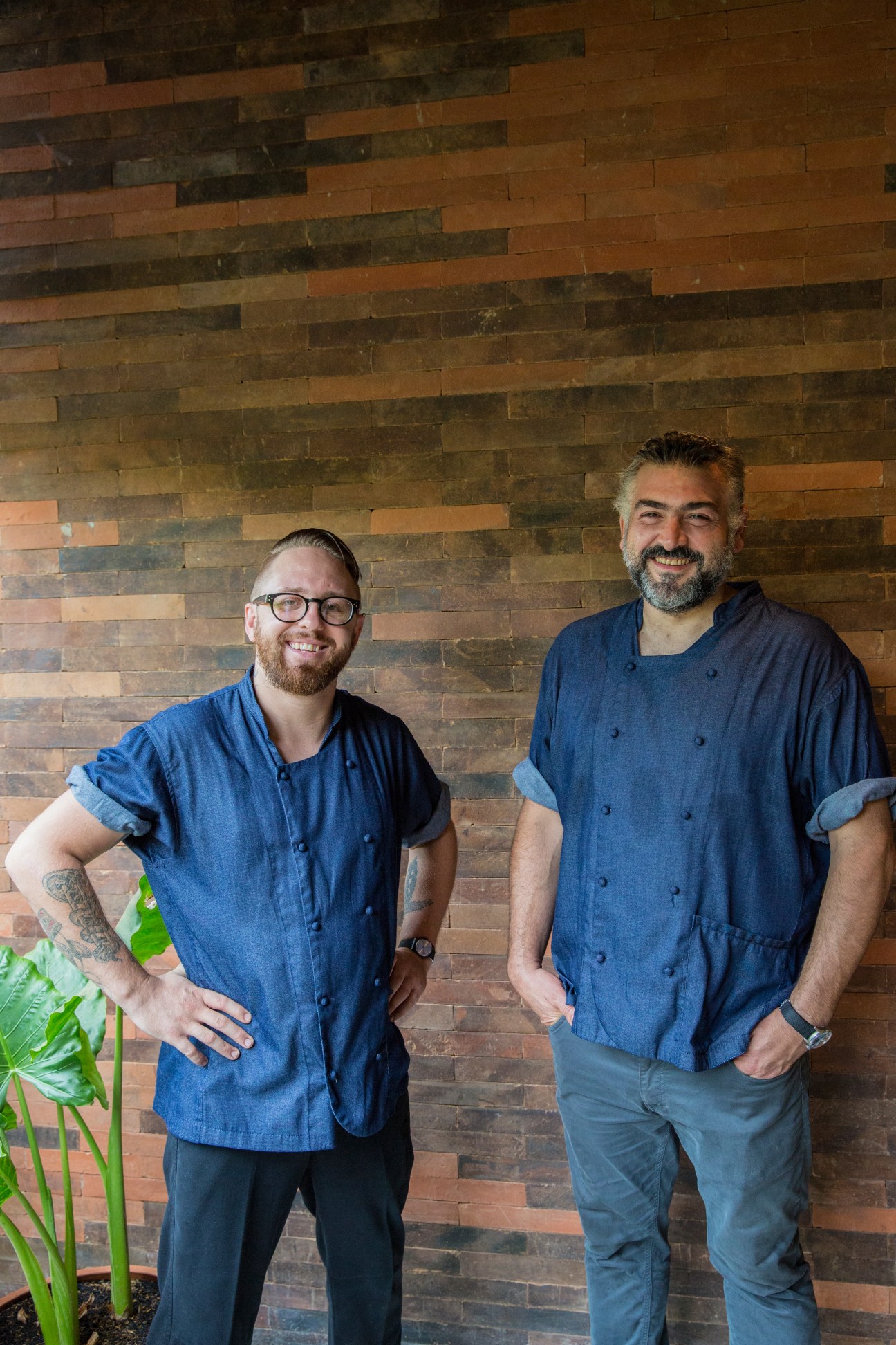 Movida head chef Jimmy Parker and chef Frank Camorra stand against a brick wall at Katamama hotel.