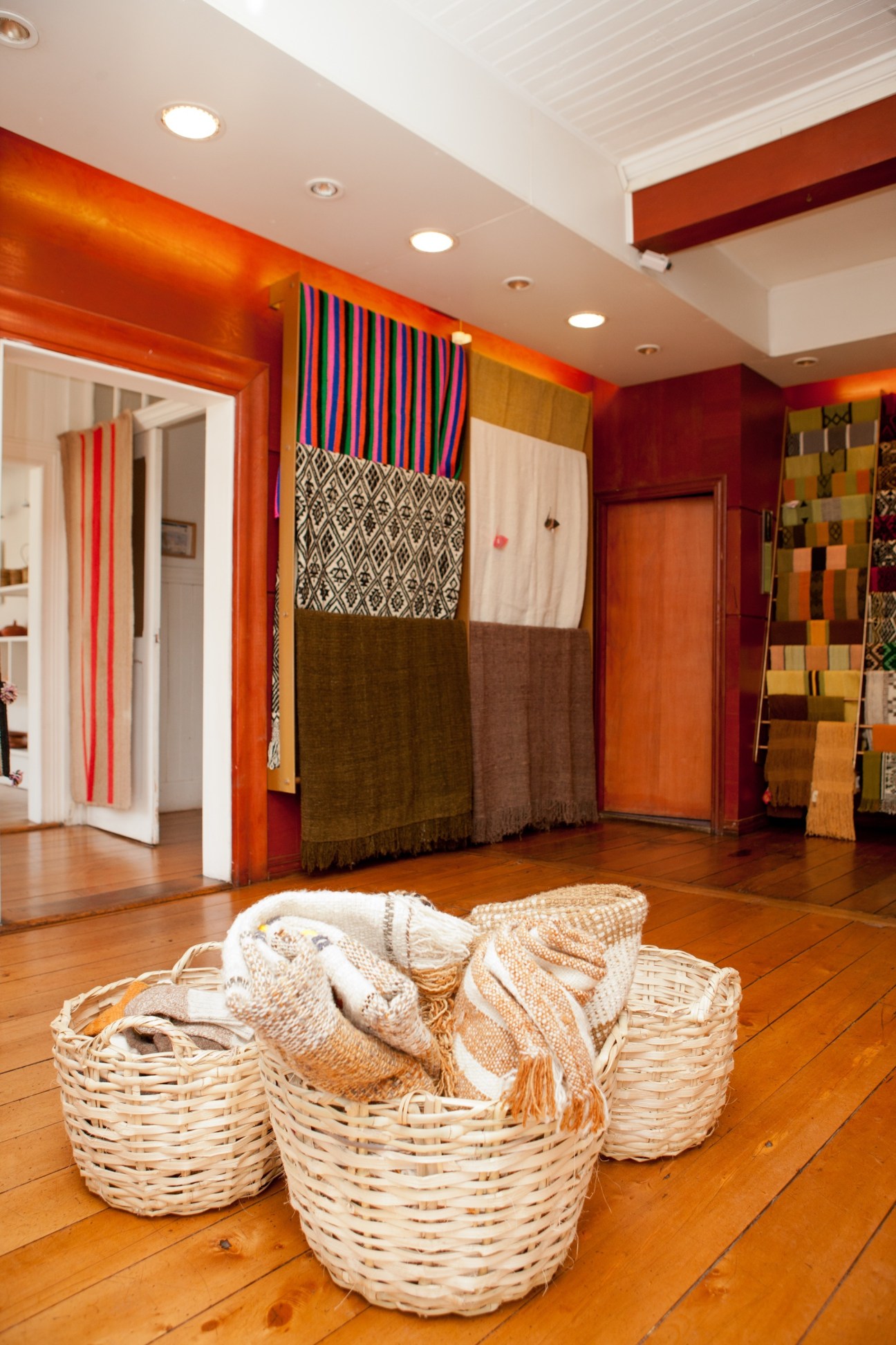Interior of Artesanías de Chile craft shop displaying woven textiles and baskets with colorful South American crafts.