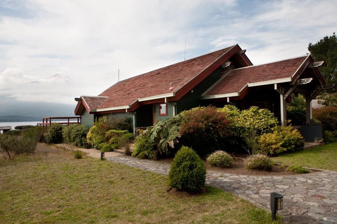 Yan Kee Way Lodge, a lakeside house with red trim and wood shingle roof overlooking Lake Llanquihue in Puerto Varas, Chile.